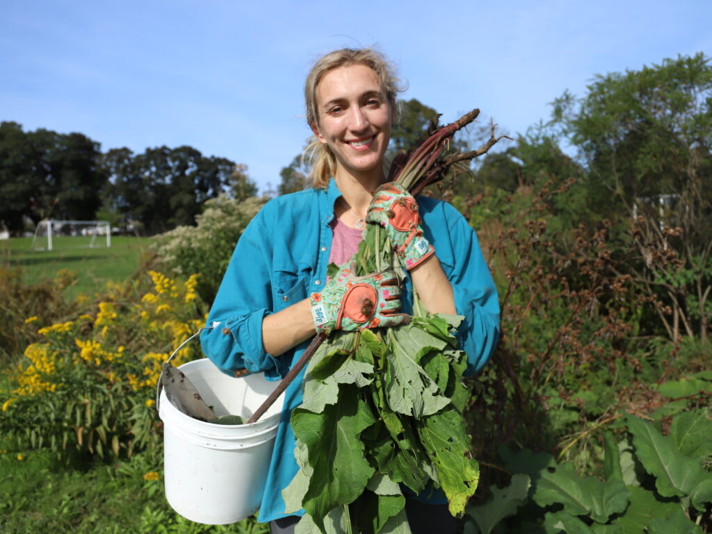 woman with bucket and hands full of root vegetables