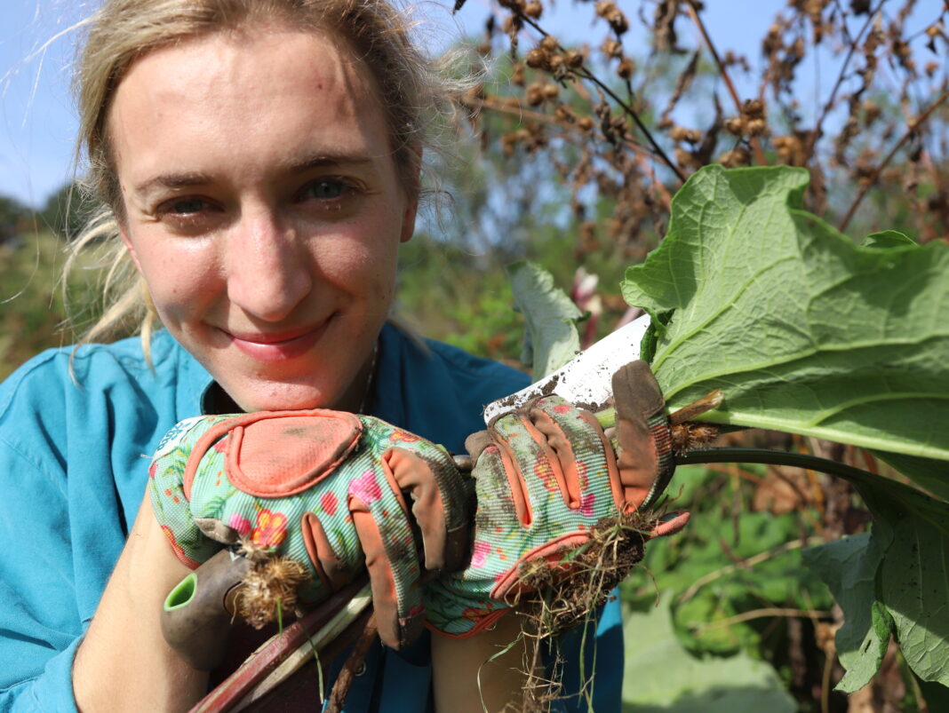 caroline with garden gloves and foraged root vegetable