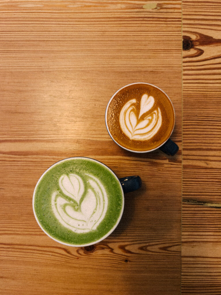 two lattes with heart and leaf designs