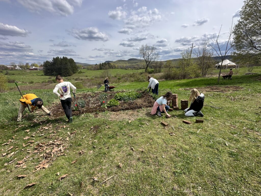 students preparing garden beds in a field